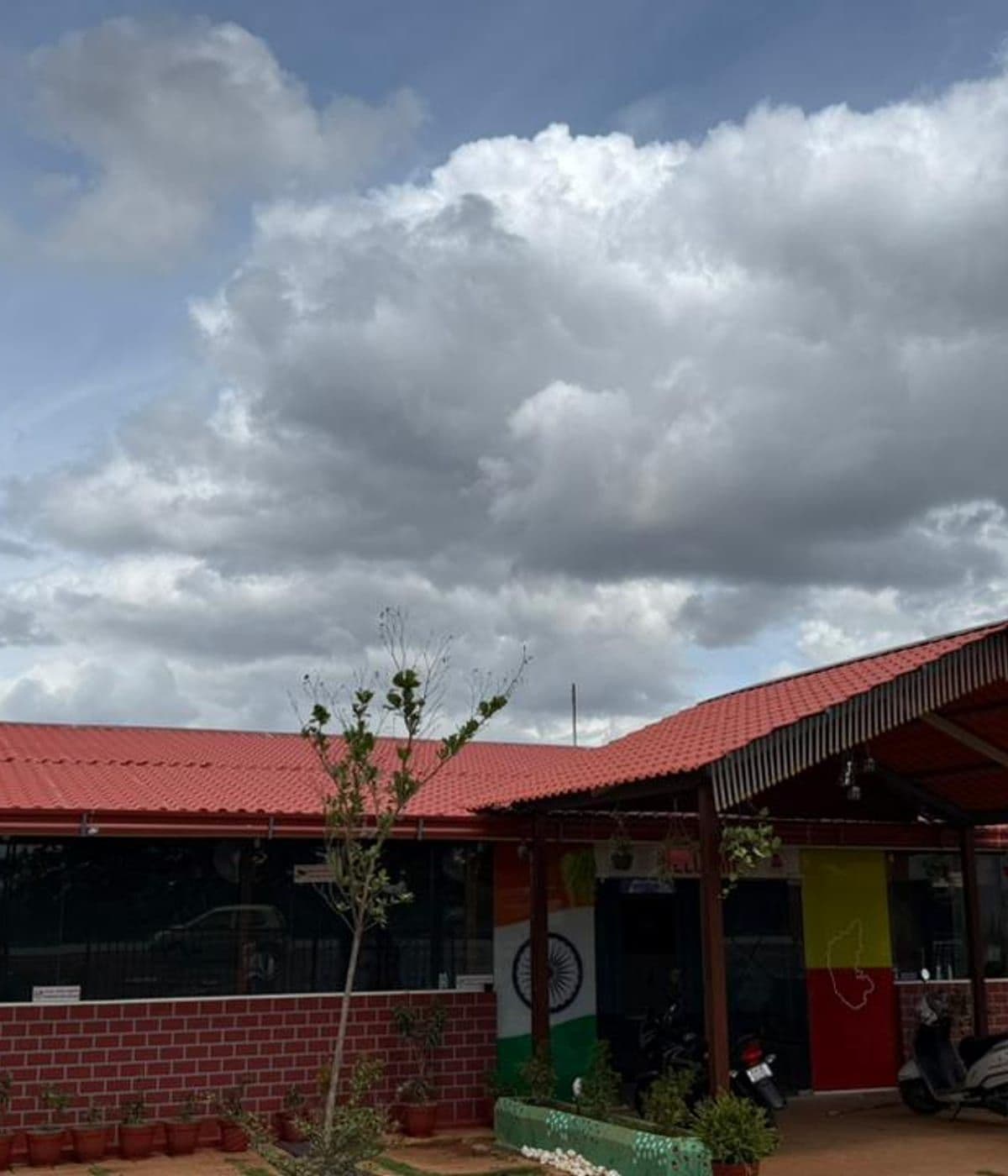 Brick front of the restaurant with the Indian tricolour painted pillars and red tin roof