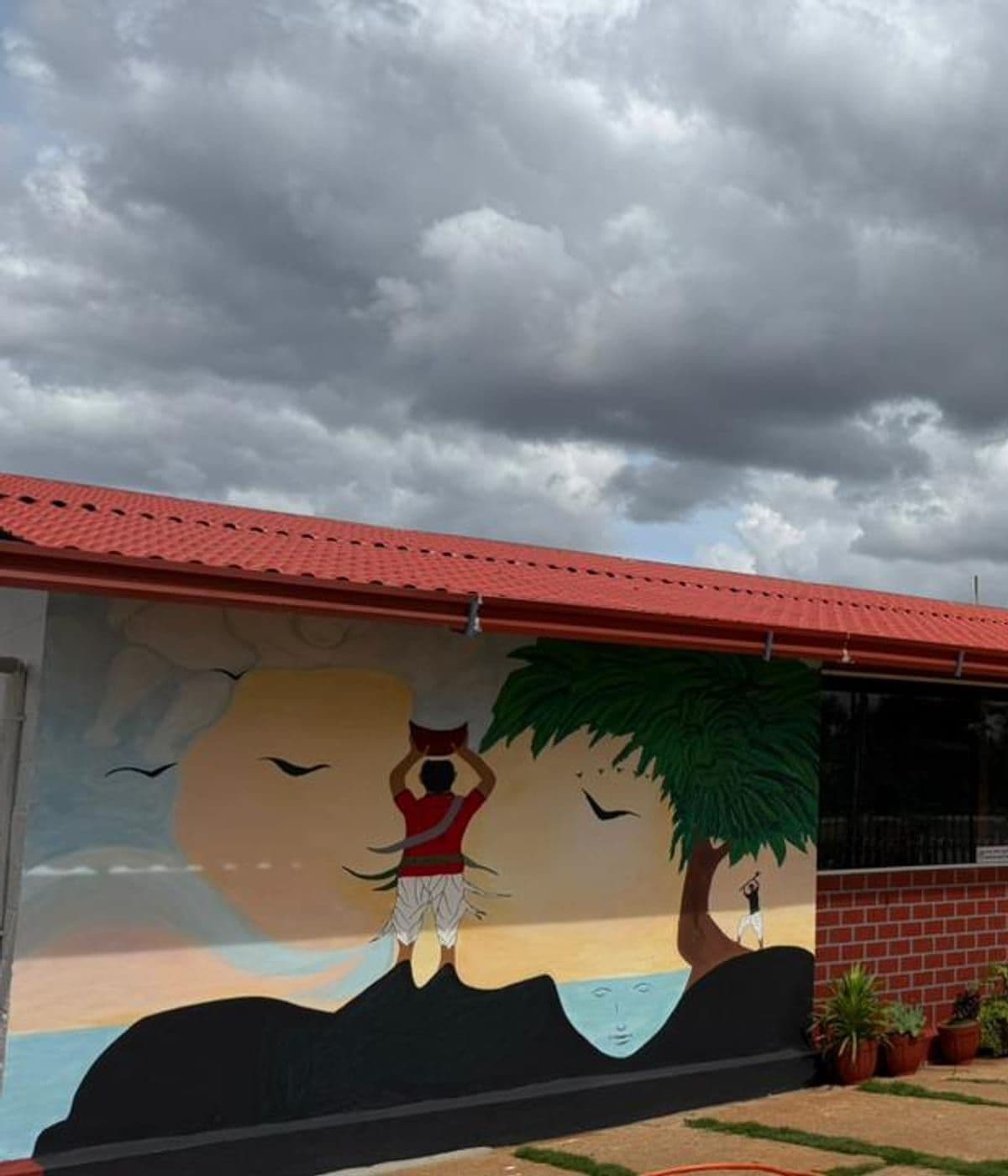 Folk-art mural of a woman carrying a pot, painted on the restaurant wall